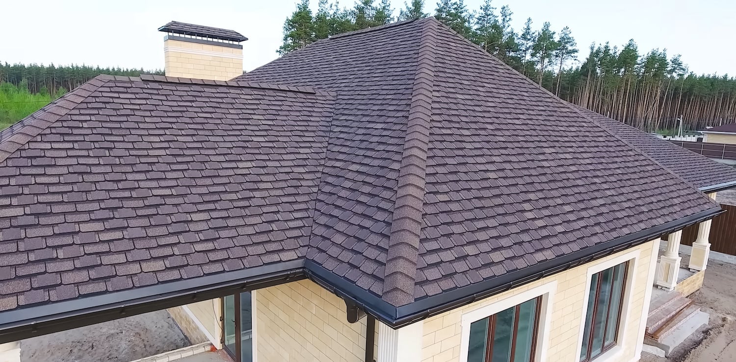 Bituminous tile for a roof. House with a roof from a bituminous tile. a roof from a bituminous tile. Moder