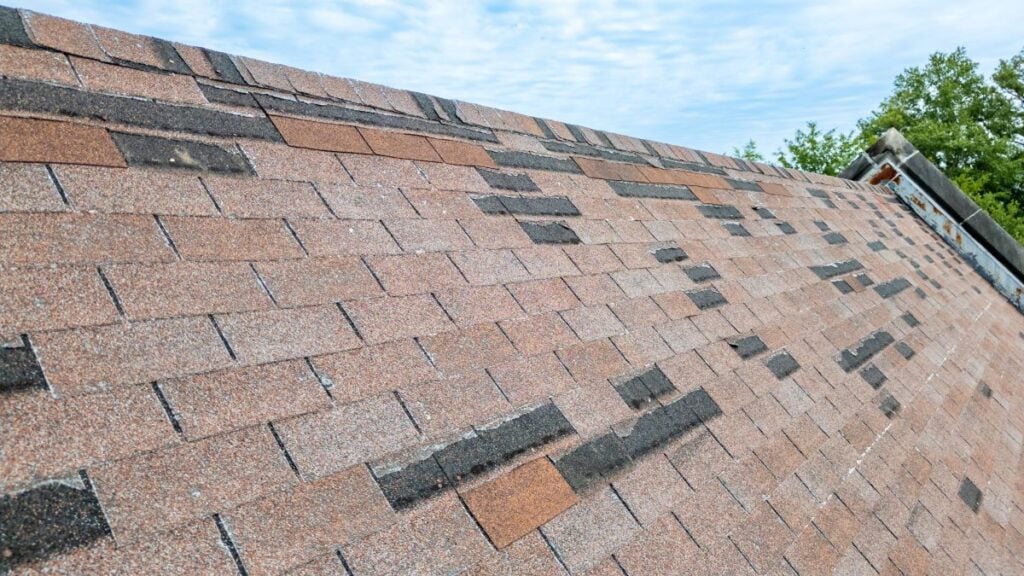 Roof with missing shingles from storm damage