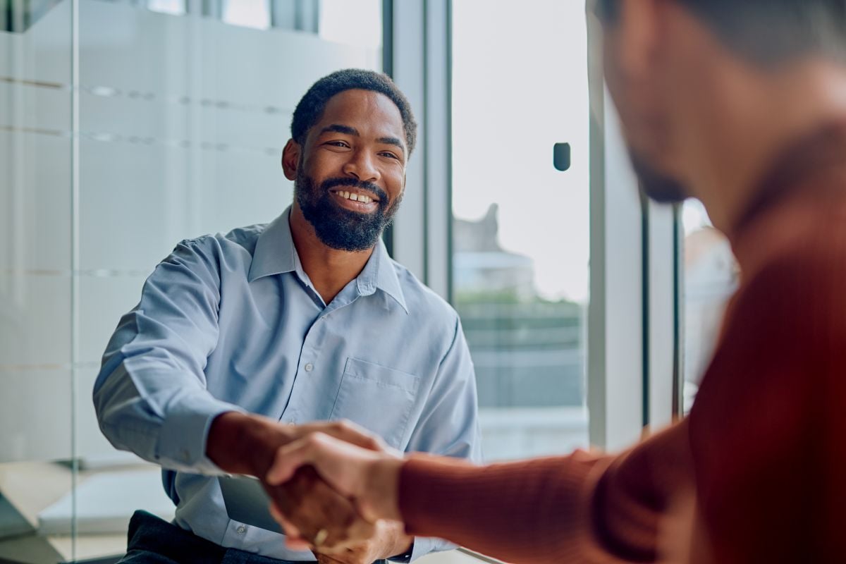 businessmen shaking hands and smiling during a meeting